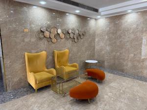 vestíbulo con sillas, mesa y pared en The Grand Mirage Hotel, en Ma‘ābīlah
