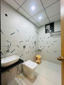 un baño con inodoro y lavabo en Hotel Sun Palace, en Somnath