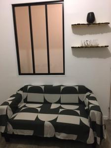 een zwart-witte bank in een kamer met een raam bij Petit T2 de charme in Eysines
