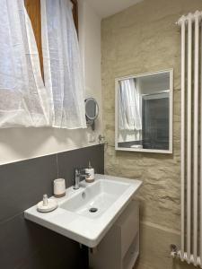 a bathroom with a white sink and a mirror at Il giardino di Chiara in Assisi +27 photos