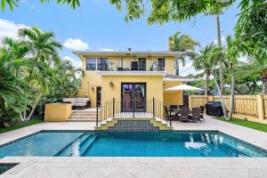 ウェストパームビーチにあるPalm Haven - Tropical Chic Home with Pool in Grandview Heightsの家の前にプールがある家