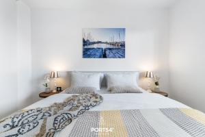 a bedroom with a large white bed with two lamps at Ferienwohnung Albatros Olpenitz in Olpenitzdorf