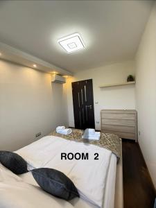 a room with a bed with a room sign on it at Local-Lux Apartman 3 szoba, privát parkoló in Kecskemét