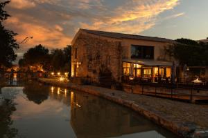 a building next to a body of water at sunset at Ile du Gua Suites in Narbonne