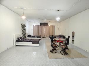 ein Wohnzimmer mit Tisch und Couch in der Unterkunft Homestay RnR CafeStay in Kampong Pengkalan Maras