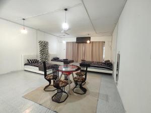 a living room with a table and chairs and a couch at Homestay RnR CafeStay in Kampong Pengkalan Maras