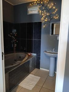 a bathroom with a tub and a sink at Motel A 2 in Criciúma