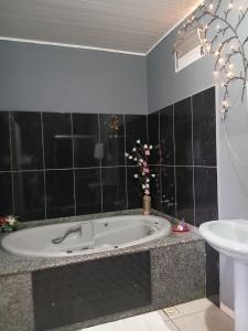 a bathroom with a bath tub and a sink at Motel A 2 in Criciúma