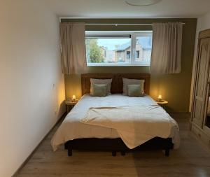 a bedroom with a large bed and a window at Frangines & Compagnie in Hotton