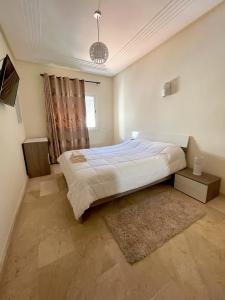 a bedroom with a large bed and a window at Résidence Ryad Albahr Herhoura in Temara