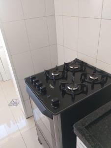 a black stove top in a white kitchen at Apartamento 200 metros da praia e próximo a comércios in Rio das Ostras