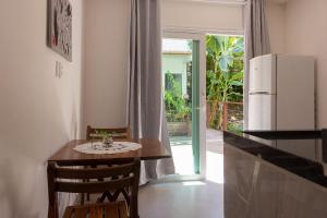 a kitchen with a small table and a refrigerator at MAR DÁ LIBERDADE com Além dos Sonhos in Morro de São Paulo