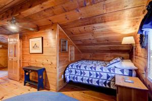 a log cabin bedroom with a bed and a desk at On The River in Banner Elk