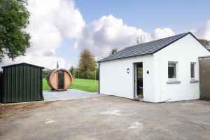 a white garage with a building in a yard at Cherry Lodge by Escape Ordinary in Coleraine