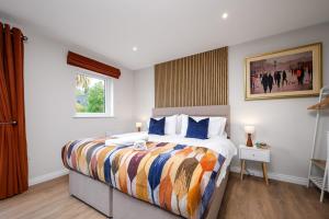 a bedroom with a large bed with a colorful blanket at Cherry Lodge by Escape Ordinary in Coleraine