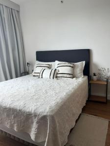 a bedroom with a bed with white sheets and pillows at Just 100 meters from Shopping del Sol in Asuncion