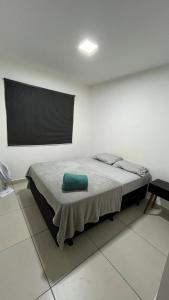 a bedroom with a bed with a green pillow on it at Apartamento Aconchego in Luziânia