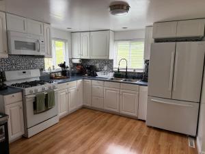 a white kitchen with white appliances and wooden floors at Susquehanna Waterfall Haven in Susquehanna