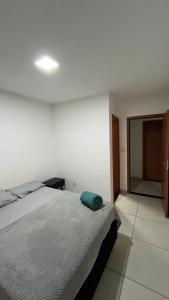 a bedroom with a bed with a green pillow on it at Apartamento Aconchego in Luziânia +23 photos