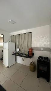 a kitchen with a refrigerator and a table in it at Apartamento Aconchego in Luziânia