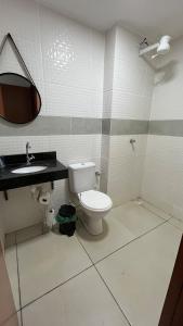 a bathroom with a toilet and a sink at Apartamento Aconchego in Luziânia
