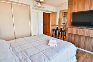a bedroom with a bed and a flat screen tv at Stylish Retreat Steps from Shopping del Sol in Asuncion +11 photos
