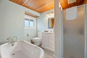 een witte badkamer met een bad en een douche bij Crystal Beach Executive Waterfront Lakehouse in Crystal Beach +56 foto's