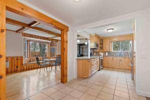 een keuken met houten kasten en een tafel en stoelen bij Crystal Beach Executive Waterfront Lakehouse in Crystal Beach