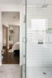 ein Badezimmer mit Glasdusche und ein Schlafzimmer in der Unterkunft Wood-Rich Niagara Loft close to Queen Street in Niagara Falls