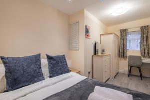 a bedroom with a large bed with blue pillows at Newly refurbed 3Bed Annexe - With Parking! in Albury