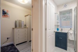 a bathroom with a sink and a blue cabinet at Newly refurbed 3Bed Annexe - With Parking! in Albury
