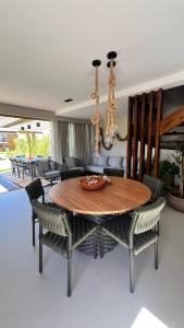 a dining room with a wooden table and chairs at Reserva dos jacarandás praia do forte in Praia do Forte