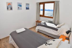 two beds in a room with a window at Del Lago Sky Hotel in San Carlos de Bariloche +50 photos