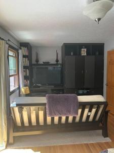a living room with a bench and a tv at Gorgeous Coal Creek Canyon Guest Suite in Coal Creek