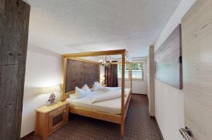 a bedroom with a bed with a wooden frame at Appartements "Da Zillertaler und die Geigerin" in Mayrhofen