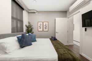 a bedroom with a large white bed with blue pillows at 2BR Cozy Apartment in DT in Spokane