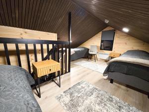 a attic bedroom with two beds and a tv at Villa Martta, Yllas, Lapland Hideaway Near Trails in Äkäslompolo