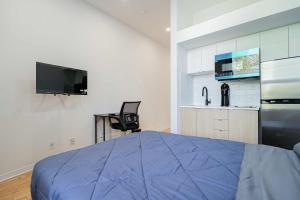 a bedroom with a blue bed and a kitchen at Fabulous Studio with FREE Parking near Montreal Downtown in Montréal