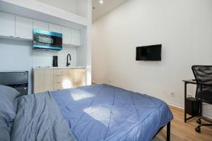 a bedroom with a blue bed and a kitchen at Fabulous Studio with FREE Parking near Montreal Downtown in Montréal +2 photos