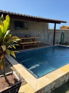 a swimming pool with a picnic table and a patio at Bangalô raizes in São Gonçalo do Amarante