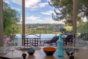 a table with glasses and a bottle on top of it at Villa Roumentas - 8 pers - Vue vallée & Piscine in Navailles-Angos