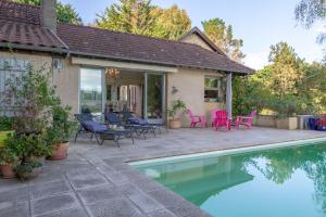a patio with a pool and chairs and a house at Villa Roumentas - 8 pers - Vue vallée & Piscine in Navailles-Angos