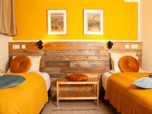 two beds in a room with yellow walls at Eric the Red Guesthouse in Reykjavík