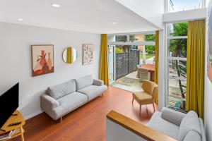een woonkamer met een bank en een tv bij QV Stays Modern Spacious Multi-Level Townhouse in Auckland