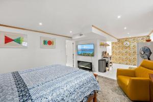 ein Schlafzimmer mit einem Bett und einer gelben Couch in der Unterkunft Modern Basement Apartment 3 Blocks from Waterfront in Tacoma