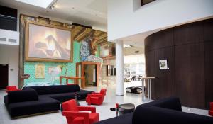 eine Lobby mit Sofas und einem Gemälde an der Wand in der Unterkunft Dutch Design Hotel Artemis in Amsterdam