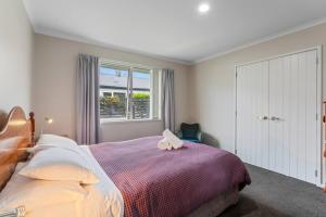 ein Schlafzimmer mit einem Bett, auf dem ein Stofftier liegt in der Unterkunft Family fun at Wharewaka in Taupo Airport