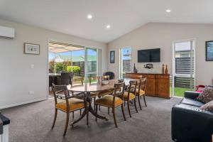 ein Esszimmer mit Tisch und Stühlen und einer Couch in der Unterkunft Family fun at Wharewaka in Taupo Airport