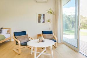 a room with two chairs and a table and a bed at Ideally Located Modern Studio Apartment in Dunsborough