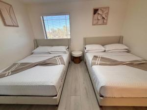 two twin beds in a room with a window at Bora Bora in Casa Grande